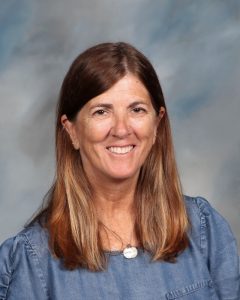 Smiling educator in denim shirt posing for school portrait