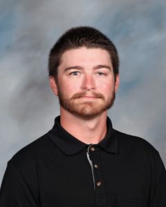 Person in black polo shirt against blurry background